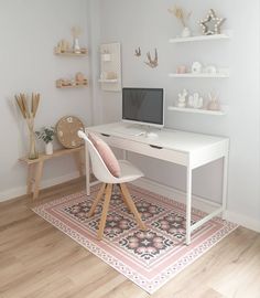 a white desk with a computer on top of it in a room filled with shelves