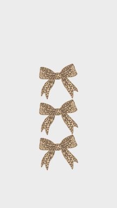 three bows on top of each other in brown and white leopard print, against a gray background