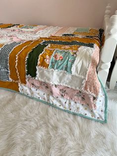 a white bed with a colorful quilt on it