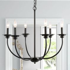 a black chandelier with five lights hanging from it's centerpiece in a white room