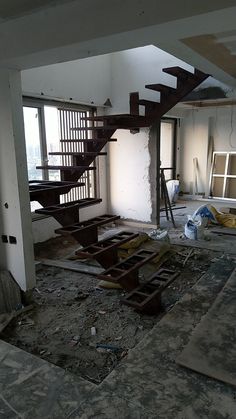 an empty room with some stairs in the middle and debris on the ground around it