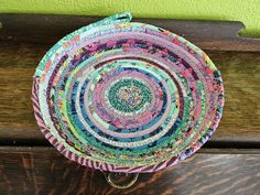 a multicolored basket sitting on top of a wooden bench