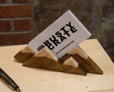 a pen sitting on top of a wooden table next to a sign that says brazy