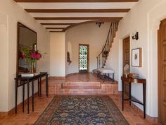 an entry way with a rug on the floor and stairs leading to another room in the house