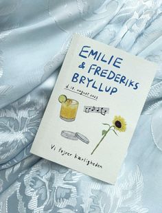 a book titled emile and friederkis brylup on a bed with blue sheets