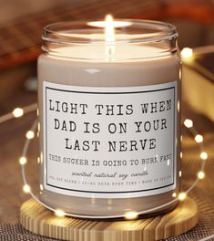 a candle that is sitting on top of a wooden coaster with lights around it and a quote written in the middle