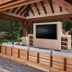 an outdoor entertainment area with built - in seating and a flat screen tv on the wall