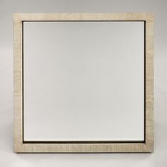 an empty square mirror on a white wall