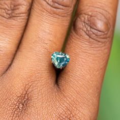 This loose stone is available for a custom ring by Anueva Jewelry. Select your stone first and then select a setting. Add both to your cart and we'll create your ring! 1.61CT HEART MADAGASCAR SAPPHIRE, SILKY PARTI TEAL BLUE GREEN, 7.33X6.50X4.37MM, UNTREATED. Rare/hard to find cut for a sapphire. This stone has parti blue and yellow segments of color. It has an even silk throughout that makes the stone glow in direct lighting, but no visible black inclusions. It will shift in color a bit from gr Heart Cut Moissanite Gemstone Jewelry, Green Heart Cut Jewelry With Accent Stones, Green Gia Certified Trillion Cut Jewelry, Gia Certified Trillion Cut Green Jewelry, Green Aquamarine Gemstone Jewelry, Turquoise Sapphire Jewelry For Anniversary, Gia Certified Oval Aquamarine Jewelry, Unique Green Sapphire Jewelry, Blue Emerald Jewelry For May Birthstone