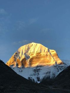 a snow covered mountain with the sun shining on it