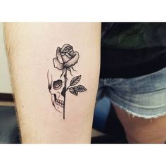 a skull and rose tattoo on the right arm, with one flower in it's center