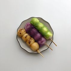 three skewers of food on a plate with toothpicks sticking out of them