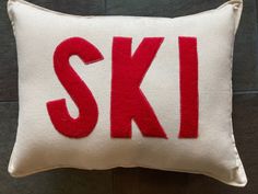 a white and red pillow with the word ski embroidered on it's front side