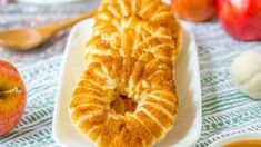 an apple cider bread is on a plate next to some apples and other fruit