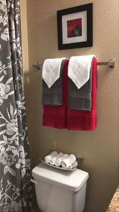 a bathroom with two towels hanging on the wall and a toilet in front of it