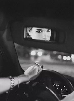 a woman sitting in the driver's seat of a car