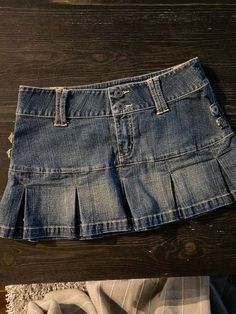 a denim skirt laying on top of a wooden floor