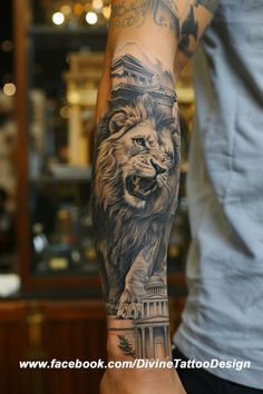 a man's arm with a lion tattoo on it and a clock tower in the background