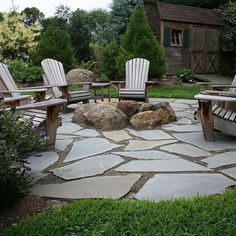 a stone patio with chairs and rocks in the middle