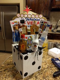 a gift box filled with liquor bottles on top of a counter next to a refrigerator