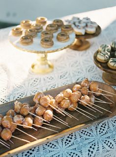 an assortment of pastries are displayed on a wooden platter at a wedding reception