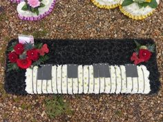 there is a cake with flowers on it and some other decorations around the cake in the shape of piano keys