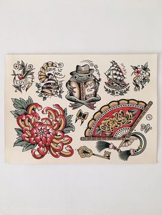 an old school tattoo design on a sheet of paper with flowers and other tattoos around it