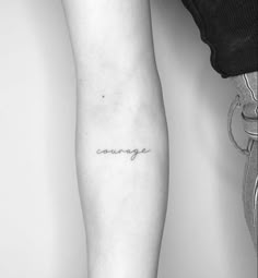 a woman's arm with the word courage tattooed on her left forearm and foot