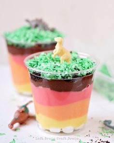 two dessert cups filled with green and red frosting, topped with a toy horse