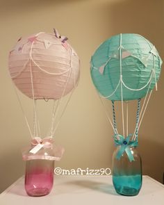 two colorful hot air balloons in a vase on a white tablecloth with pink and blue dyes