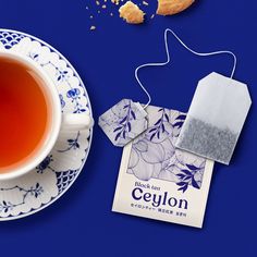 a cup of tea next to a cookie on a blue background with the label for ceylon