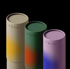 three different colored cylindrical vases sitting next to each other