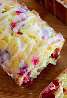 a loaf of lemon raspberry bread with icing on a wooden cutting board