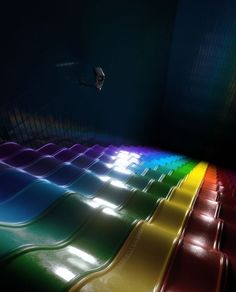 rows of rainbow colored seats in a dark room