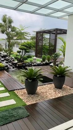 an outdoor area with plants and rocks in the center, along with a wooden deck