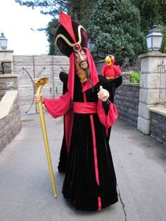 a man in costume holding a stick and wearing a mask