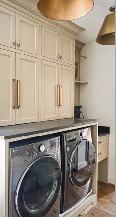 a washer and dryer in a room with cabinets