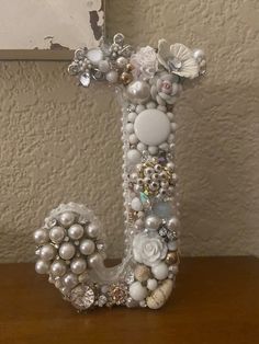 the letter j is decorated with pearls and seashells