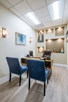 two blue chairs sitting in front of a wooden desk