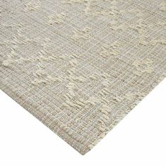 an area rug with white and beige colors on the floor, it looks like carpet