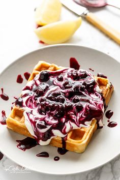 a waffle topped with blueberry sauce and whipped cream