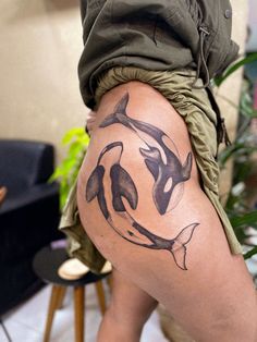 a woman's thigh with an orca whale tattoo on her leg and bottom