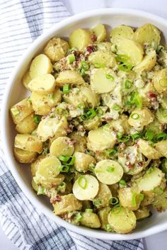 a white bowl filled with potato salad on top of a blue and white towel