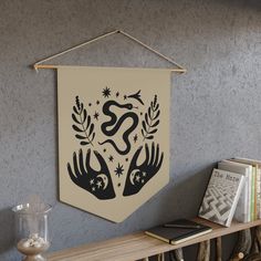 a wall hanging on the side of a wooden shelf next to a bookshelf