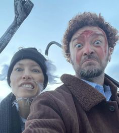 a man and woman pose for a selfie in front of an antelope