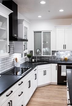 a kitchen with black counter tops and white cabinets