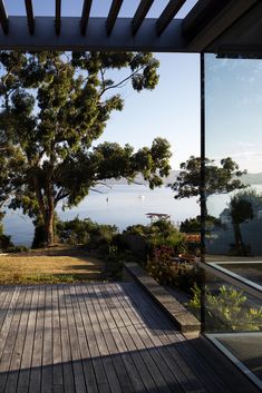 a wooden deck with trees and water in the background