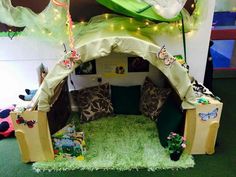 a child's play tent with lots of toys and decorations on the floor in front of it