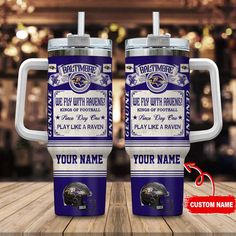 two personalized travel mugs with the baltimore ravens name on them sitting on a wooden table