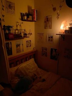 a bedroom with pictures on the wall and a bed in front of a light that is turned on